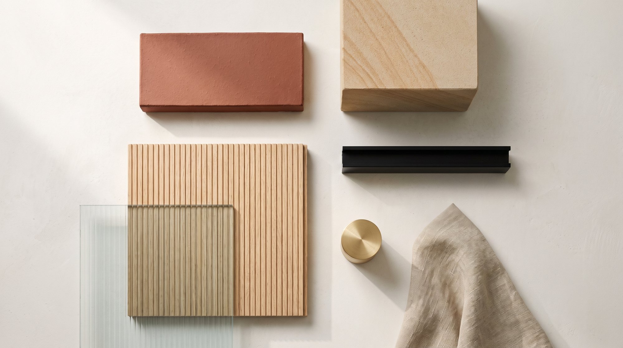 Materialpalette mit Terrakotta, Eiche, Messing und Stein